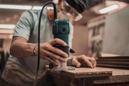 Man using a rotary tool to even out a wood's surface