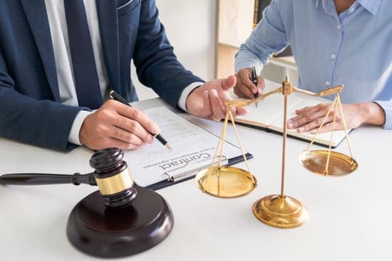 Legal assistant writing down notes during a meeting with her boss