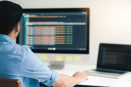 Man working with codes on his desktop and laptop
