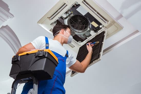 AC technician checking the air conditioner on the ceiling