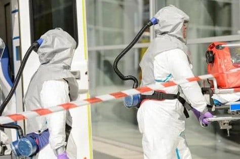 People wearing protective clothing while handling hazardous waste