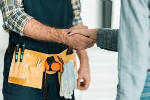 Woman shaking the hands of their plumber