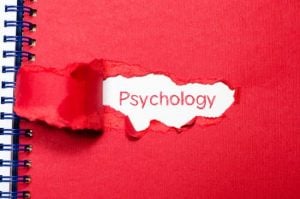 The word psychology appearing behind torn paper.