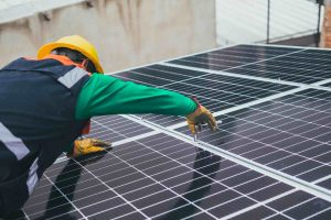 A technician tightening the bolts on the solar panel