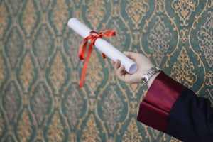 A graduate holding a diploma
