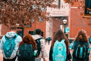 Students walking on campus, all wearing backpacks