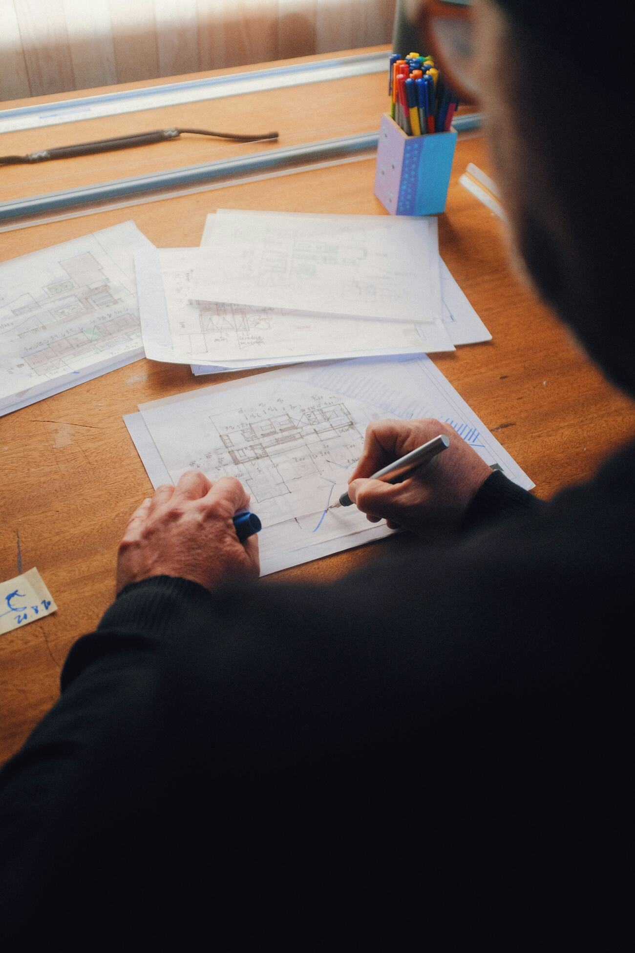 A man working on a blueprint layout at a table