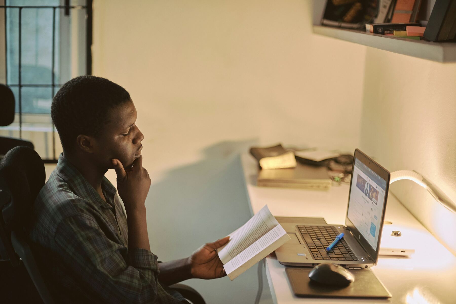 Man with his hand on his chin while reading a book