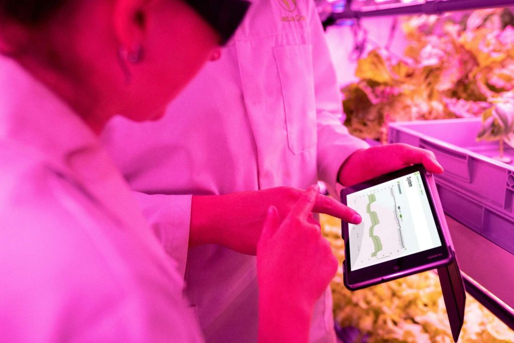 Two scientists wearing white coats are checking data in a laboratory