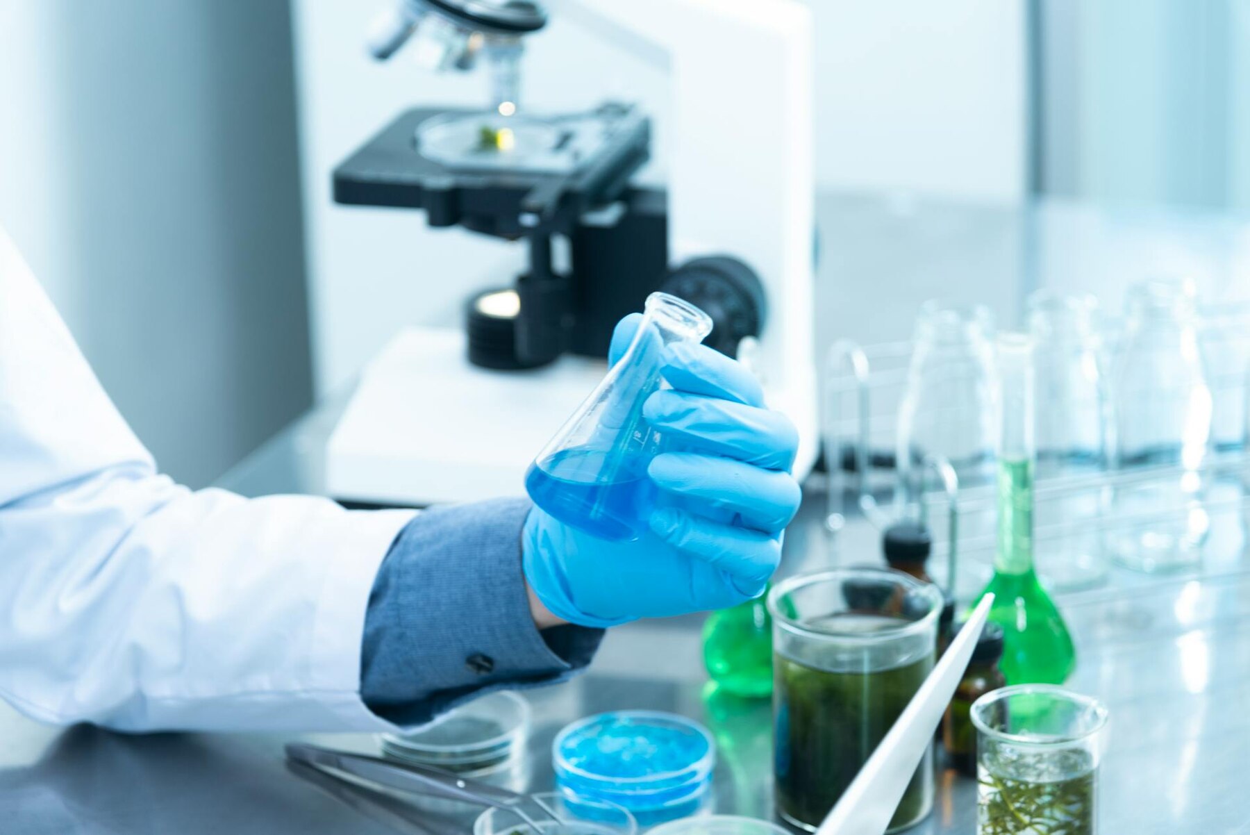 A man in white coat holding chemical tube