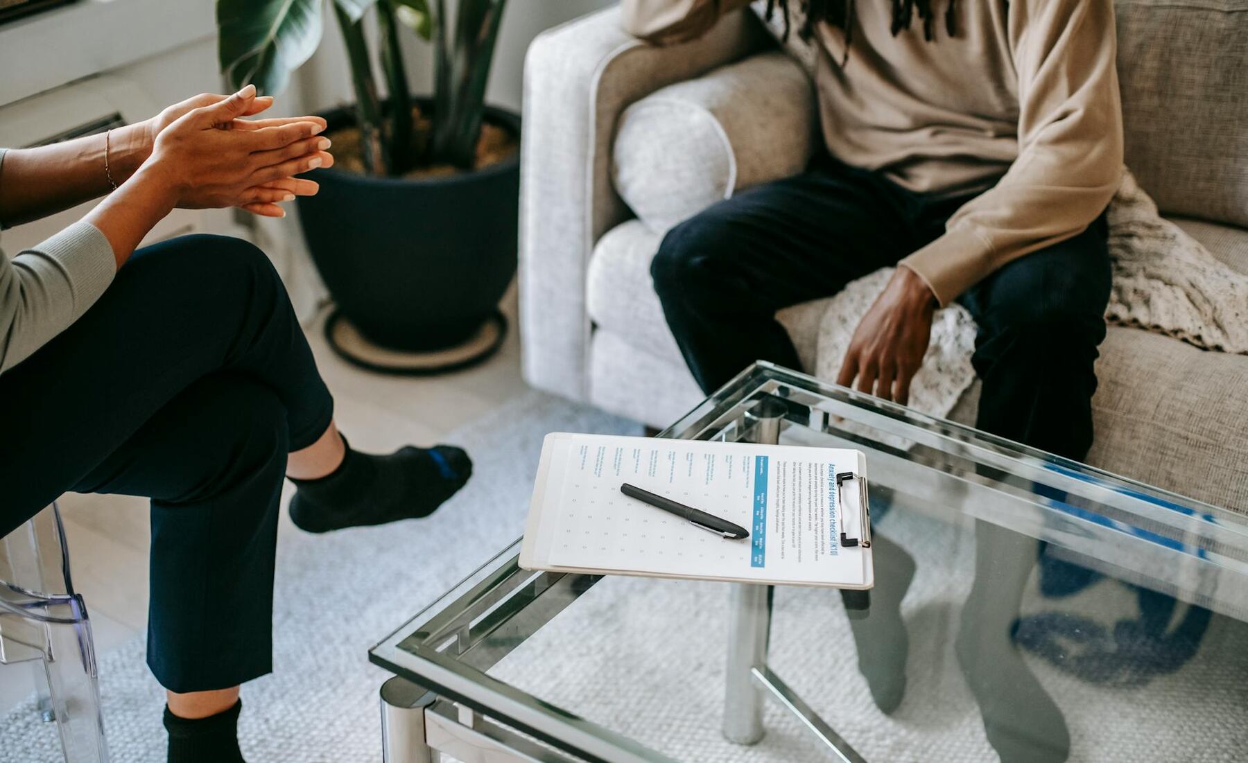 A man and woman engaged in conversation while sitting on a couch