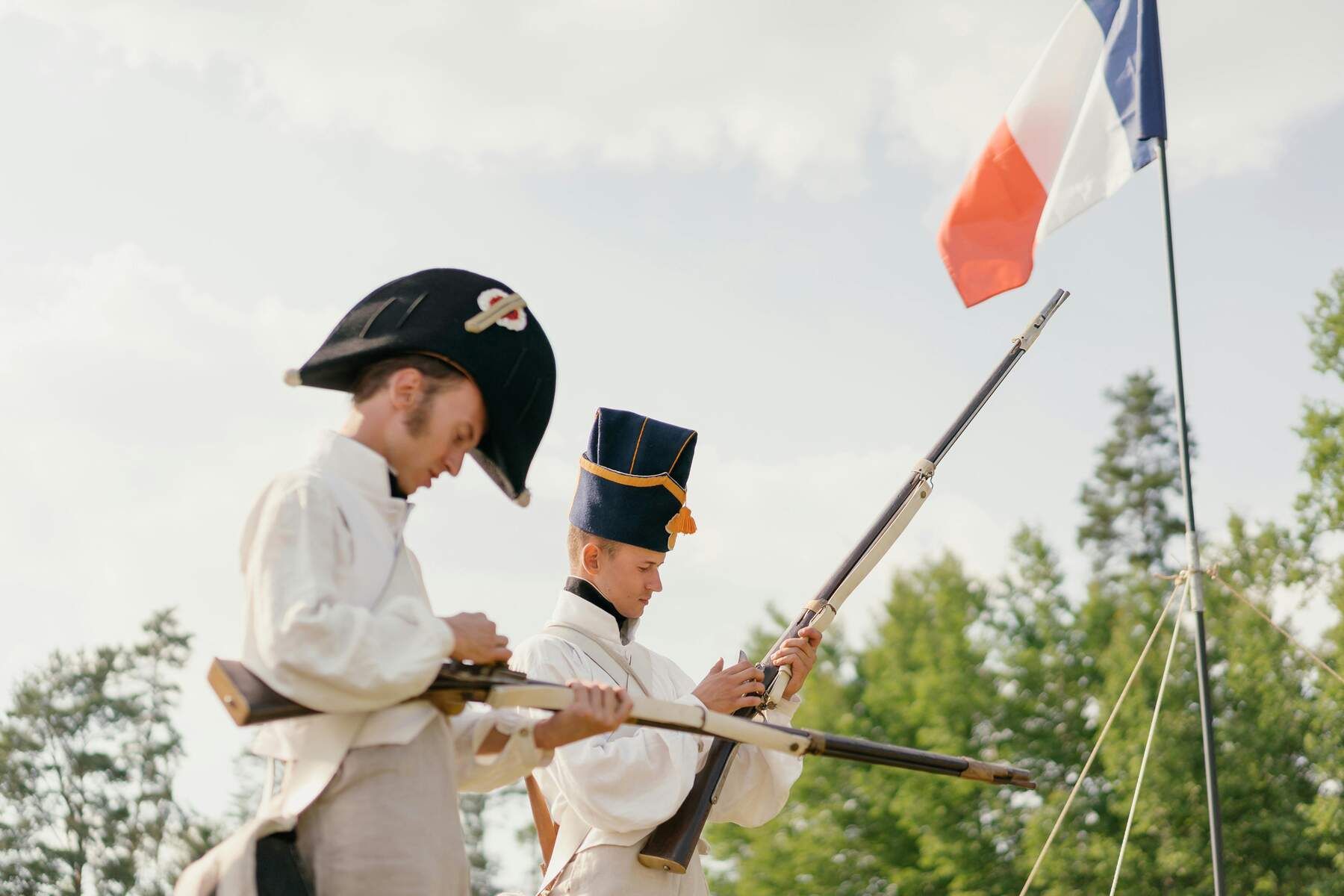 Two military individuals holding a training riffle