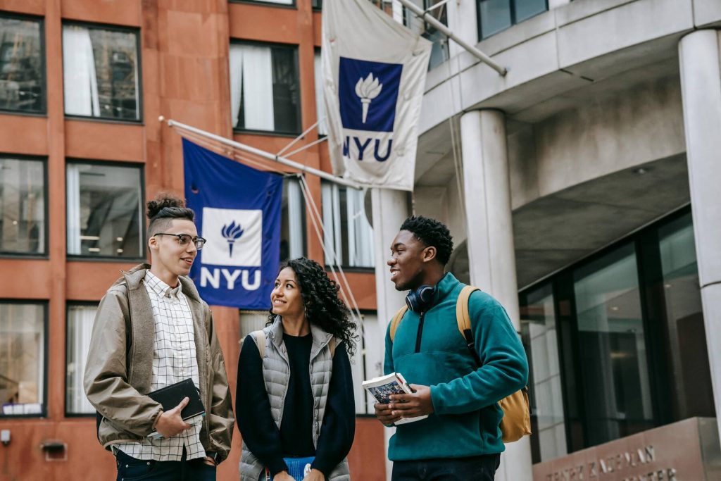 Three students talking together on campus at NYU
