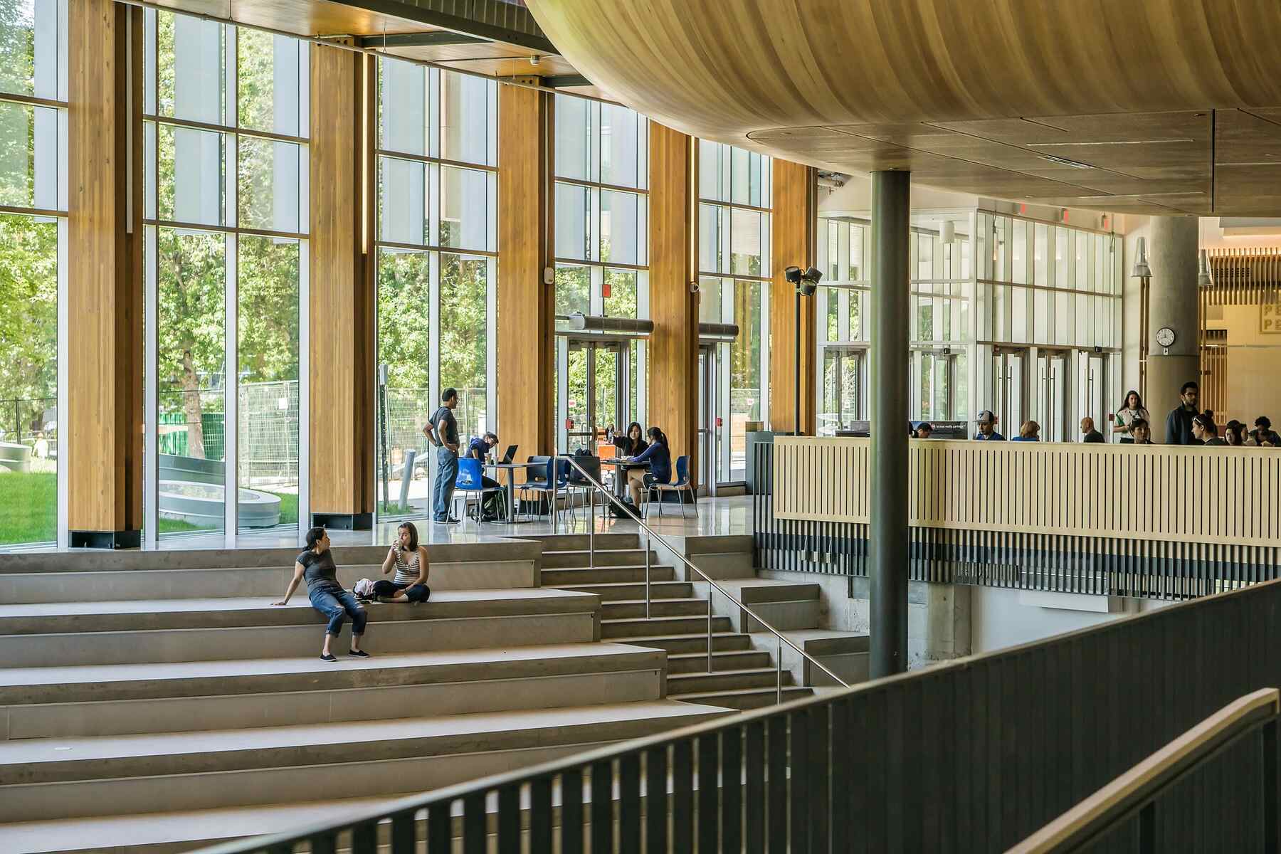 People sitting on stairs in a building, engaged in conversation