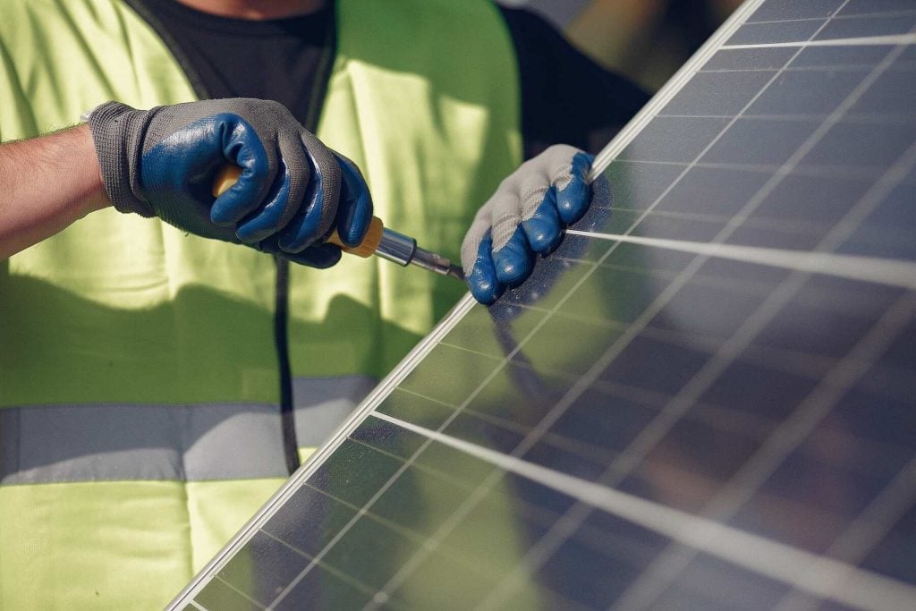 Man installing solar panels on a building