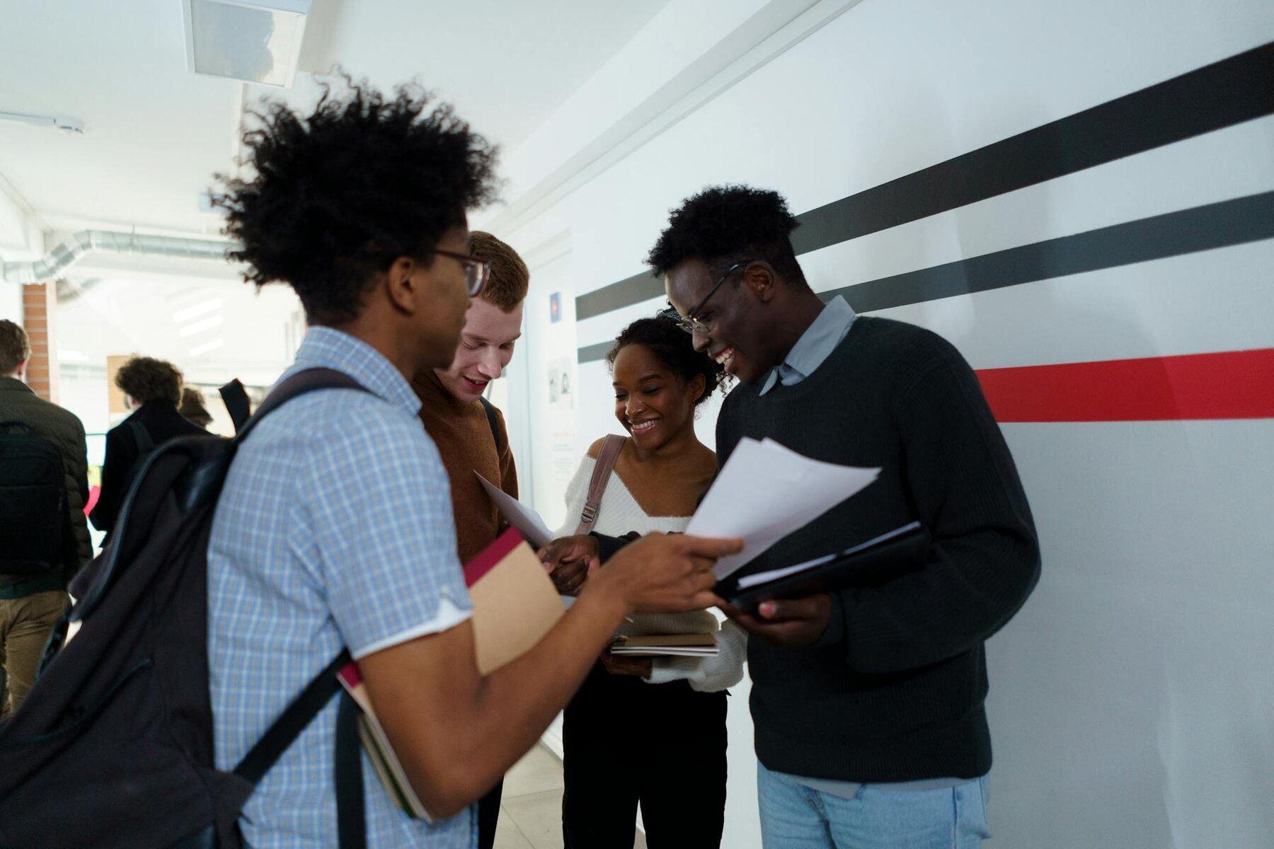 Students of various ethnicities standing together in a corridor