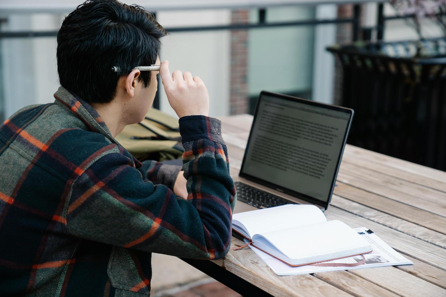 A man sitting at a table with a laptop