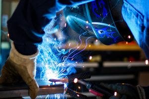 Man with protective gear welding metals
