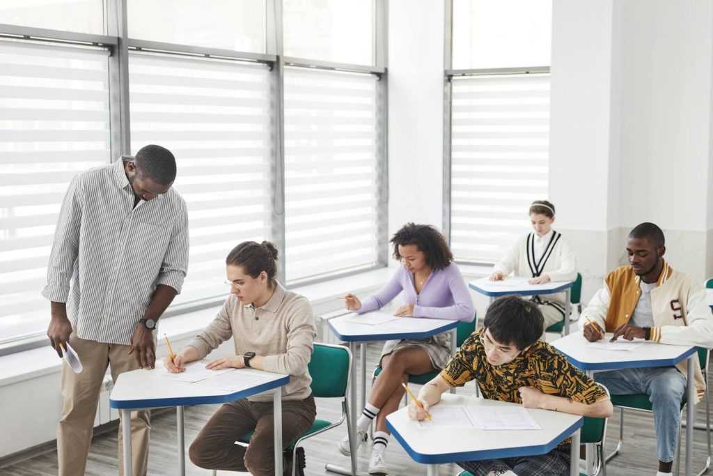 A teacher stands in front of a classroom filled with students
